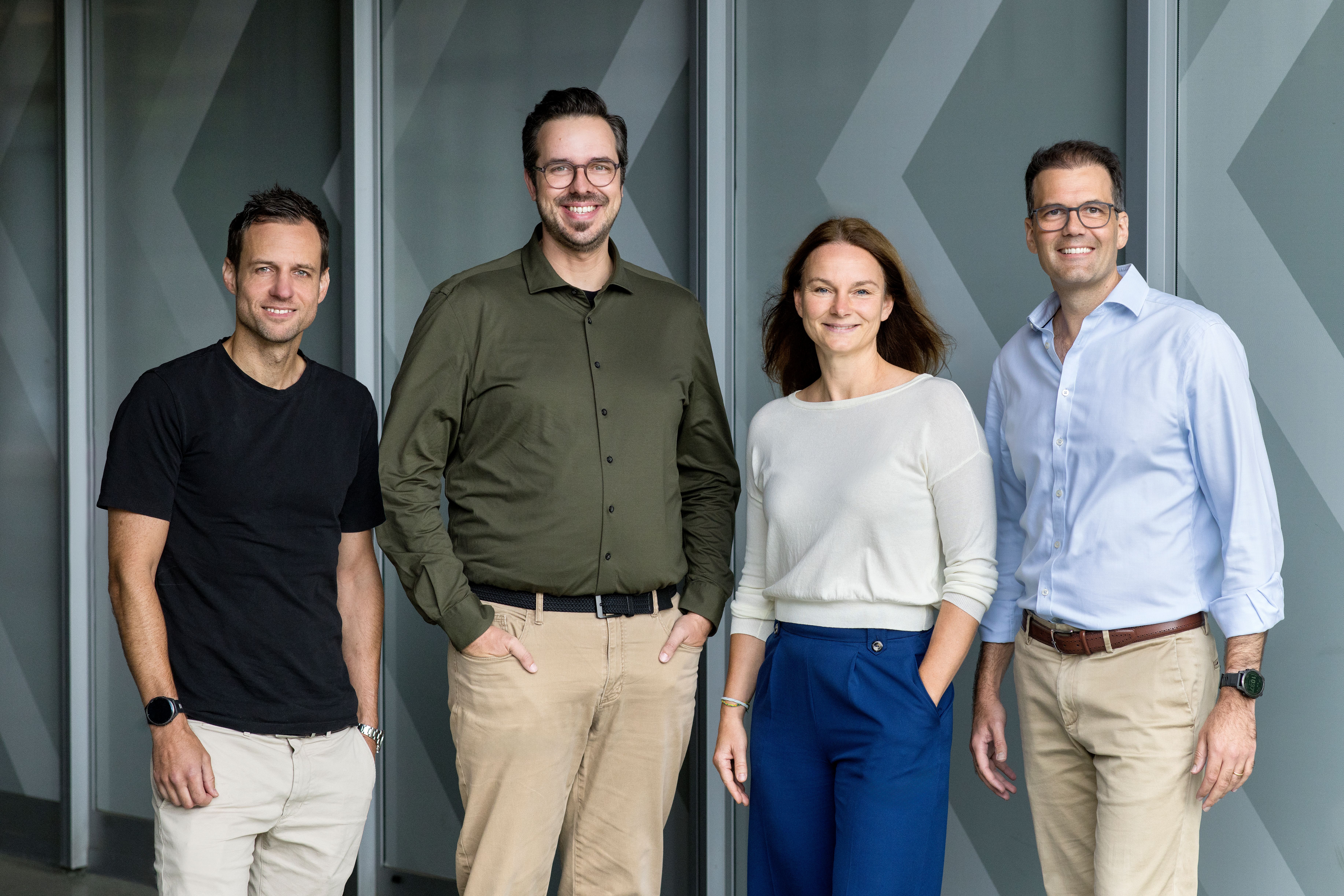 Das vierköpfige Core Management der Next Kraftwerke GmbH vor einem Next-gebrandeten Hintergrund